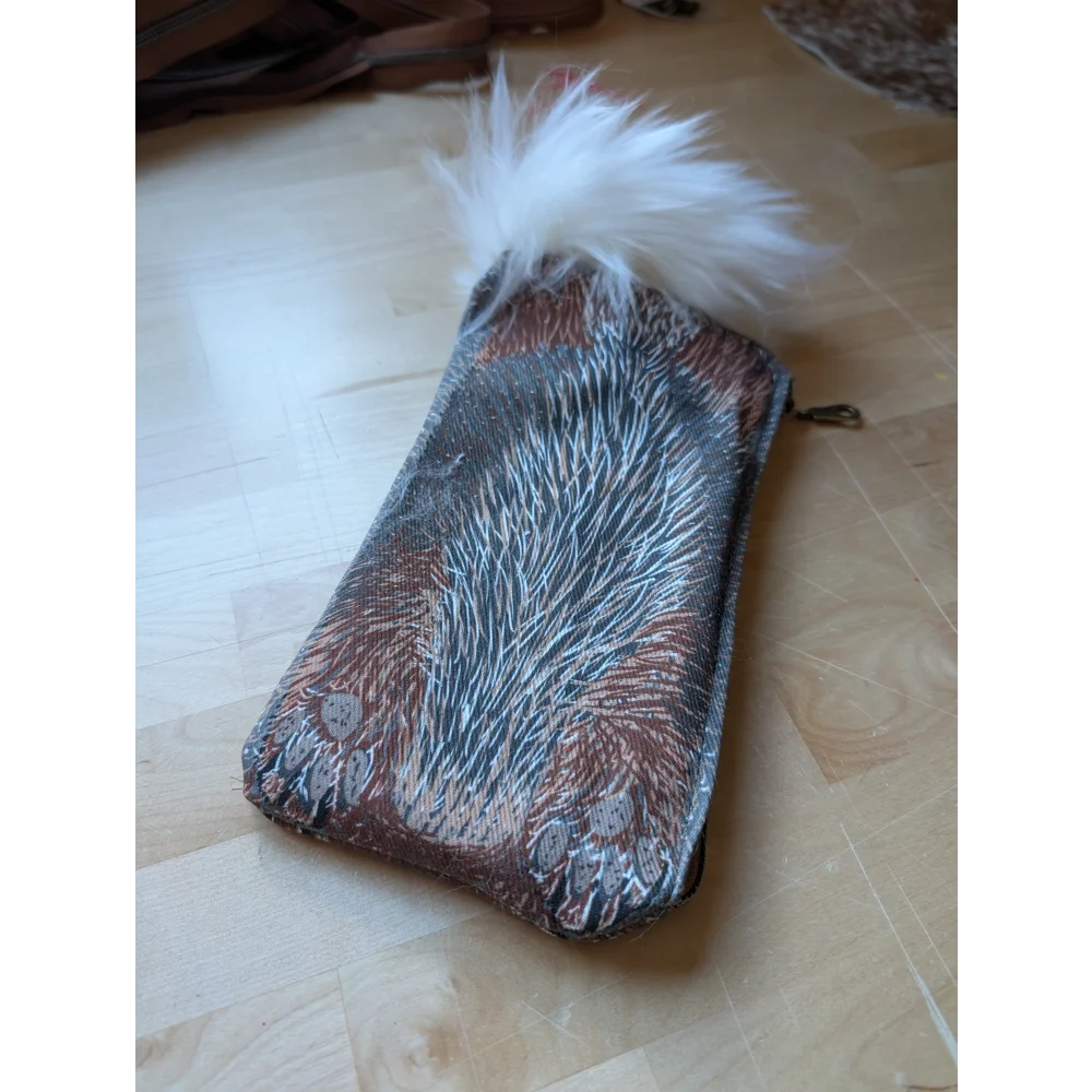 Bunny coin purse with cotton canvas fabric and brown gray feather pattern topped with fluffy white sheepskin tail