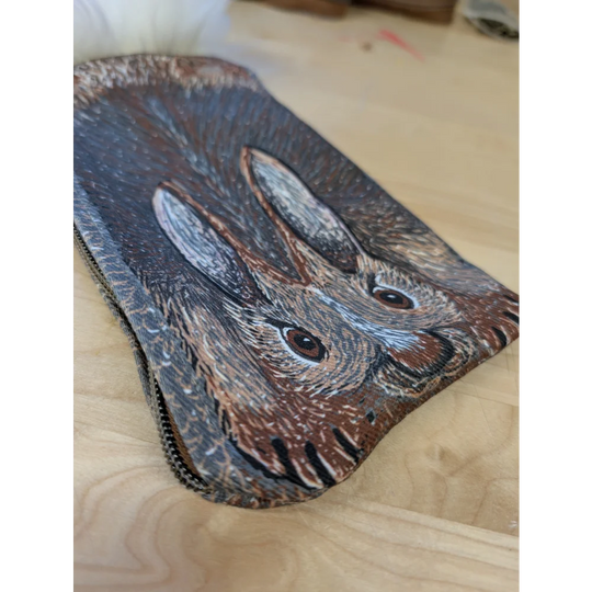 Brown leather coin purse with sheepskin tail featuring a hand-painted hare and textured fur details
