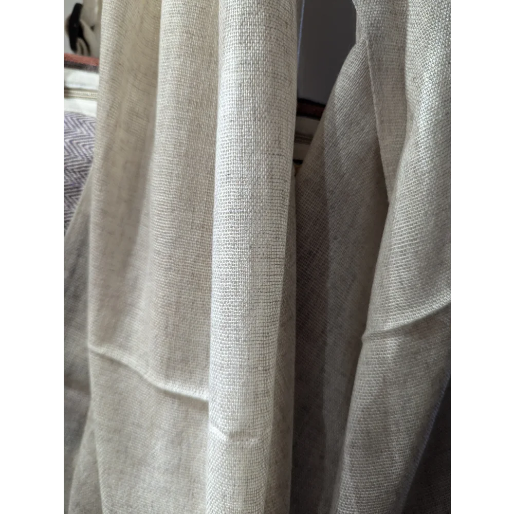 Cream-colored linen curtains with woven texture, like an Angus Oliver cashmere scarf