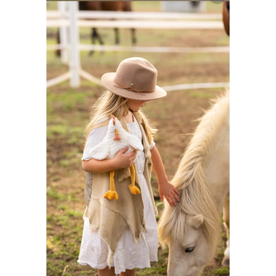 Charlie The Chicken beige white layered dress with brown hat yellow tassels Angus Oliver sheepskin rug