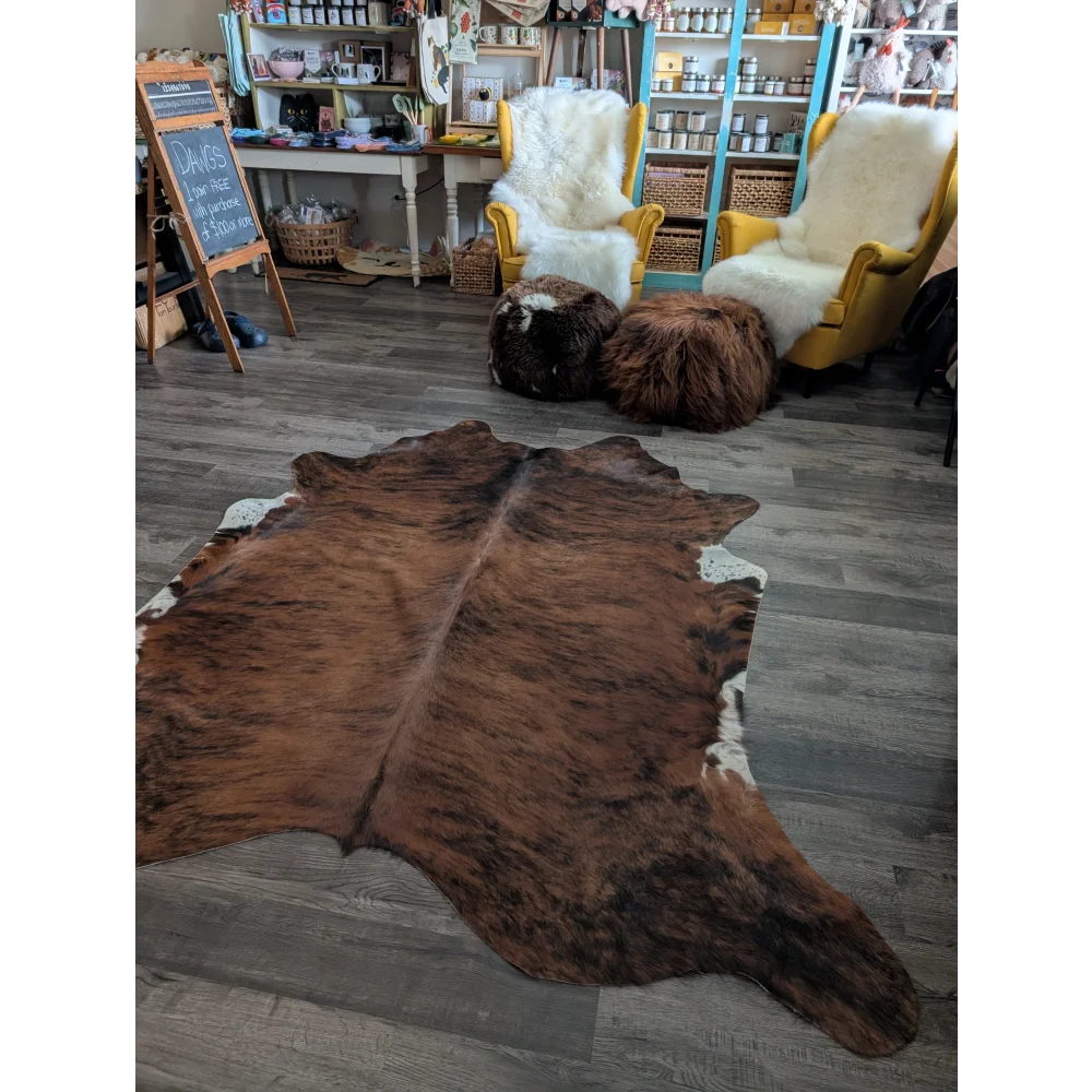 Brown and white large cowhide rug with natural irregular edges showcasing unique characteristics for beautiful rugs