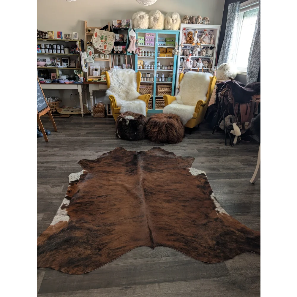 Large brown and white cowhide rug with natural fur texture showcasing unique characteristics and beautiful rugs style