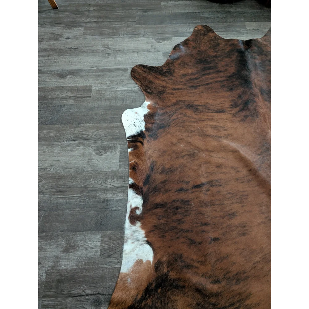 Large cowhide rug in brown and white with natural fur texture showcasing unique characteristics and beautiful rugs style