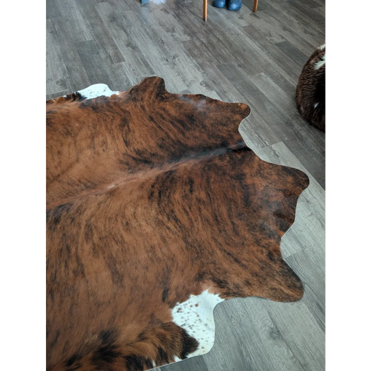 Large cowhide rug in brown and white with natural fur texture showcasing unique characteristics for beautiful rugs