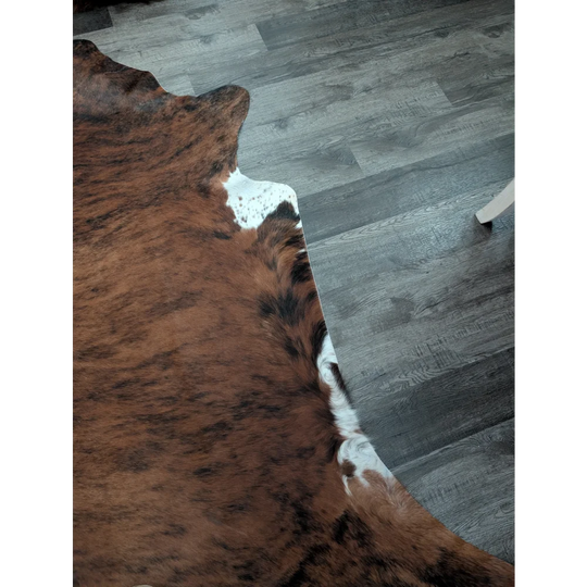 Brown and white large cowhide rug with natural fur texture showcasing unique characteristics in beautiful rugs collection