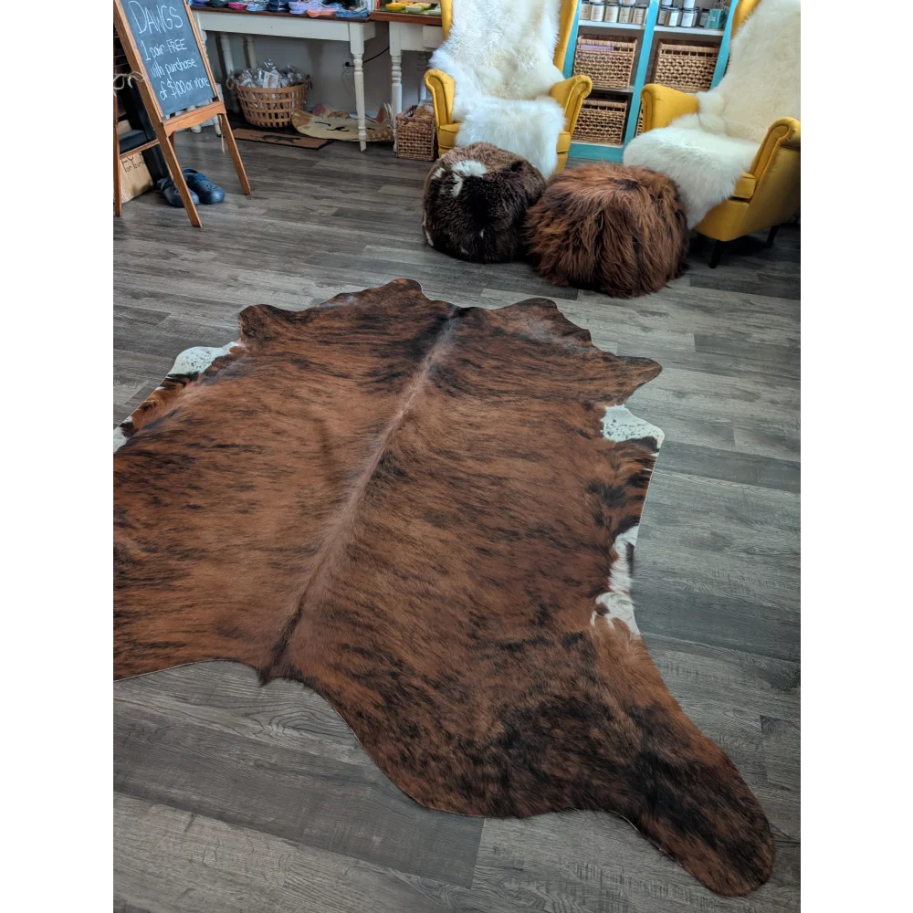 Large cowhide rug with beautiful brown and white natural fur texture showing unique characteristics