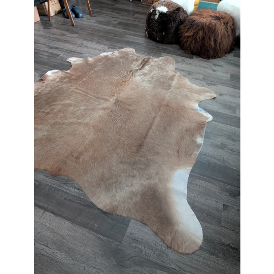 Natural tan and white large cowhide rug with soft fluffy texture showcasing unique characteristics and beautiful rugs style
