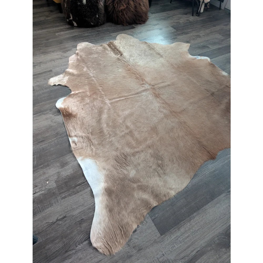 Natural tan and white large cowhide rug with soft textured surface showcasing unique characteristics for beautiful rugs