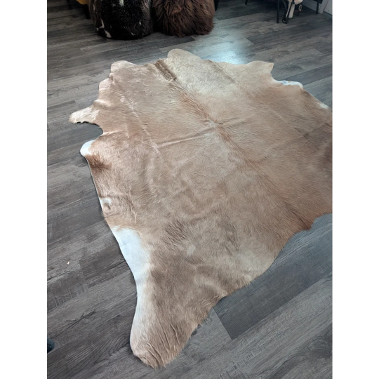 Natural tan and white large cowhide rug with soft textured surface showcasing unique characteristics for beautiful rugs