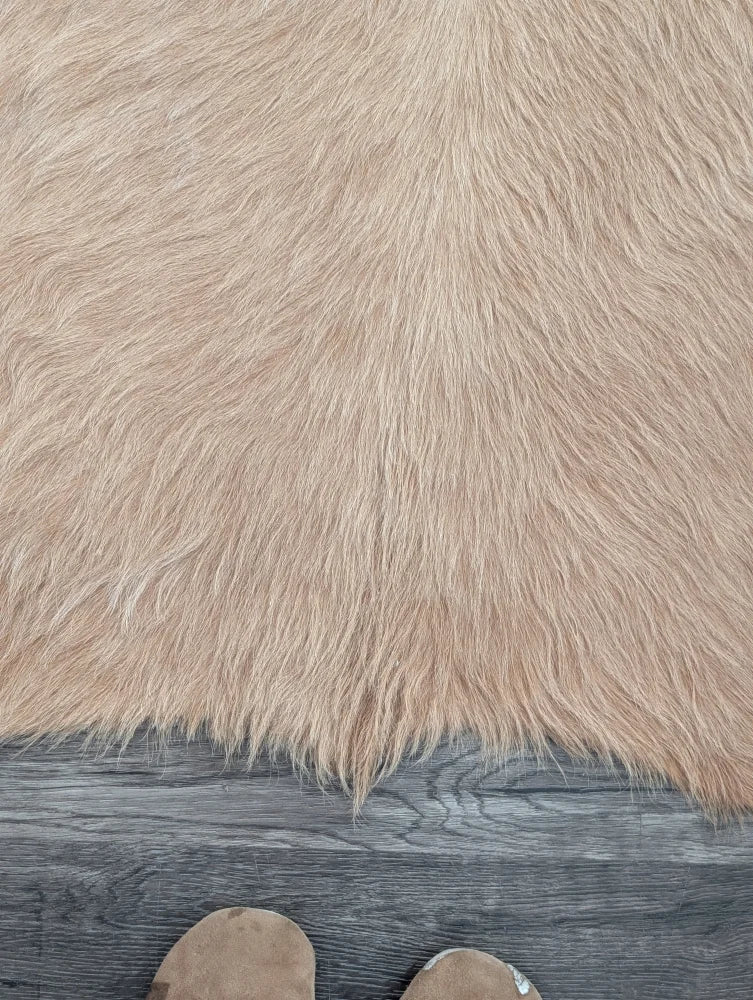 Beige faux fur large cowhide rug with long dense fibers showcasing beautiful rugs and unique characteristics on wood floor