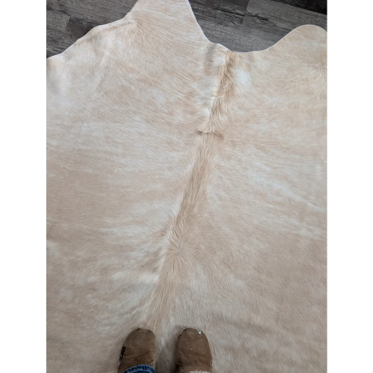 Beige large cowhide rug with natural fluffy texture and subtle tone variations perfect for beautiful rugs collection