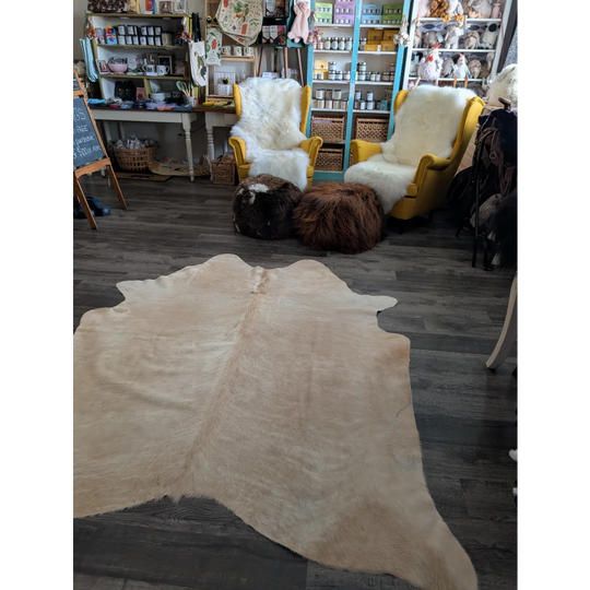 Beige large cowhide rug with natural texture and irregular edges perfect for beautiful rugs with unique characteristics