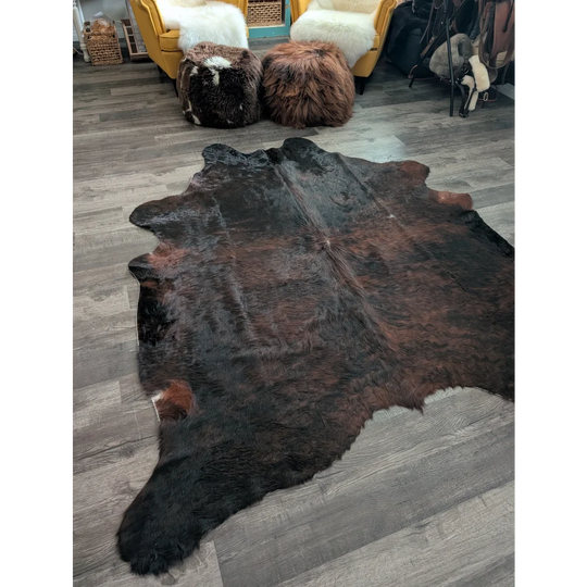 Large cowhide cow4 rug with rich dark brown and black fur showcasing unique characteristics for beautiful rugs
