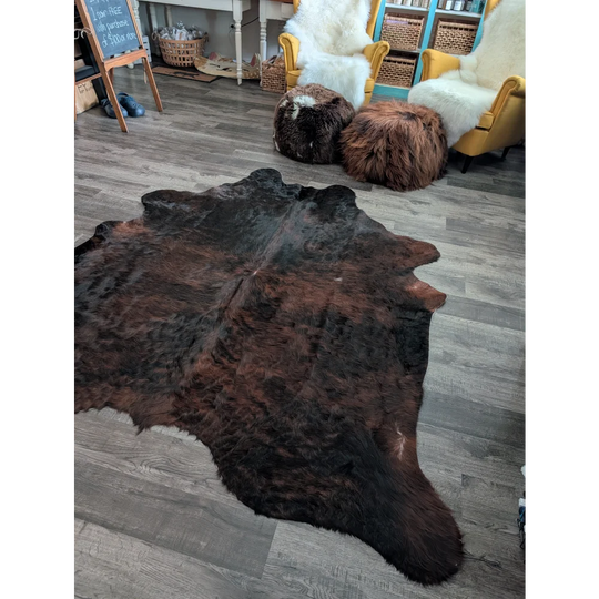 Large cowhide rug with rich dark brown and black colors and unique characteristics perfect for beautiful rugs lovers