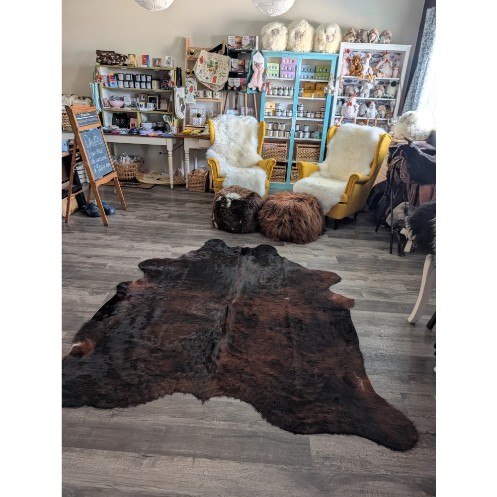 Dark brown large cowhide rug with natural fur texture and unique characteristics perfect for beautiful rugs displays
