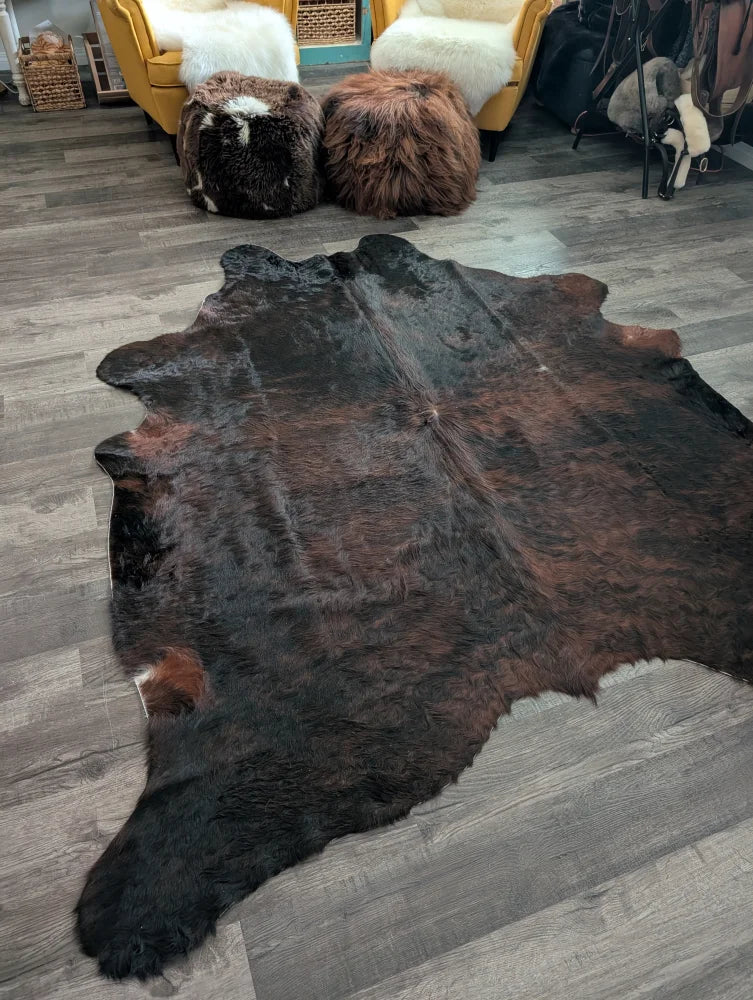 Large cowhide cow4 rug with rich dark brown and black fur showcasing unique characteristics for beautiful rugs