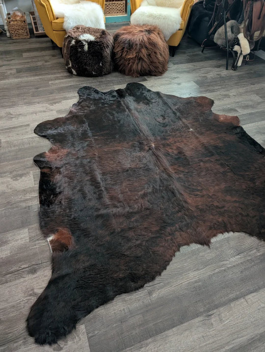 Large cowhide cow4 rug with rich dark brown and black fur showcasing unique characteristics for beautiful rugs