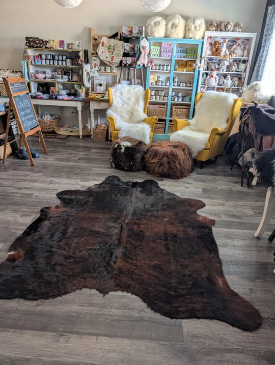 Dark brown large cowhide rug with natural fur texture and unique characteristics perfect for beautiful rugs displays