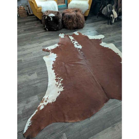 Large cowhide rug with brown and white natural irregular edges showing unique characteristics for beautiful rugs