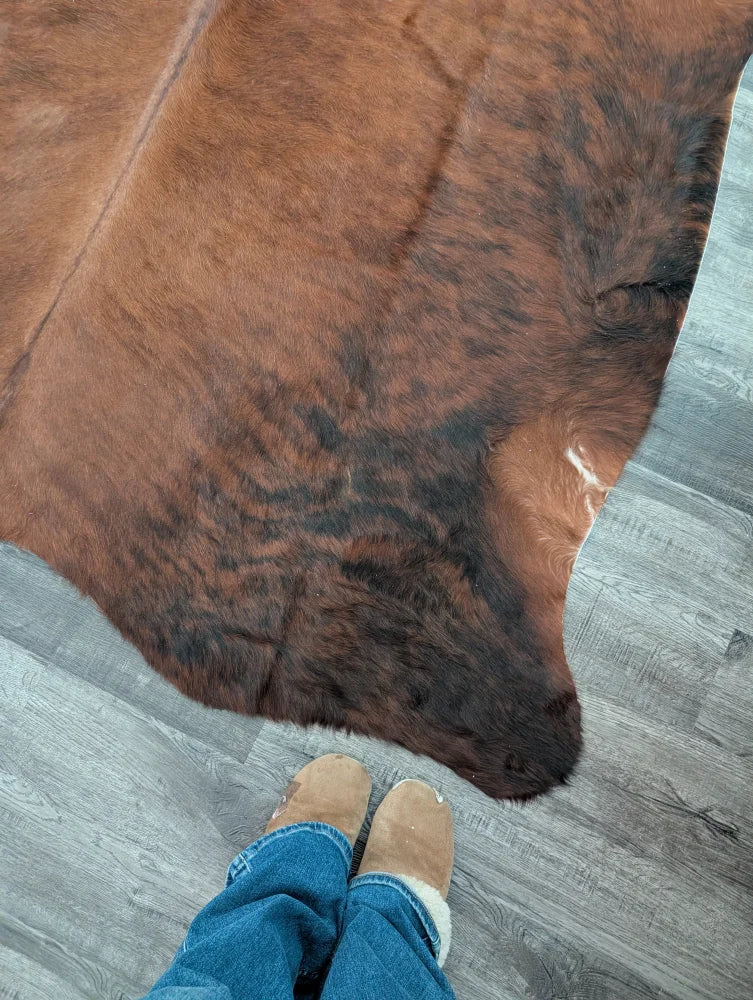 Brown and black large cowhide rug with natural fur texture showcasing unique characteristics for beautiful rugs
