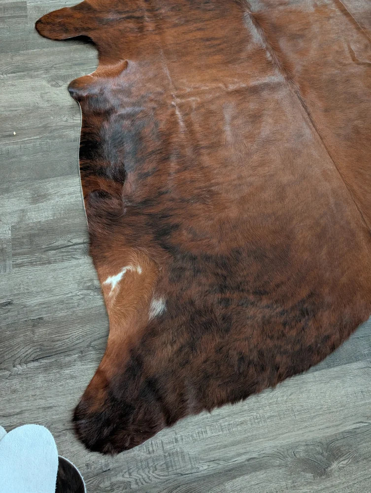 Brown large cowhide rug with natural fur texture and irregular dark patches perfect for unique beautiful rugs