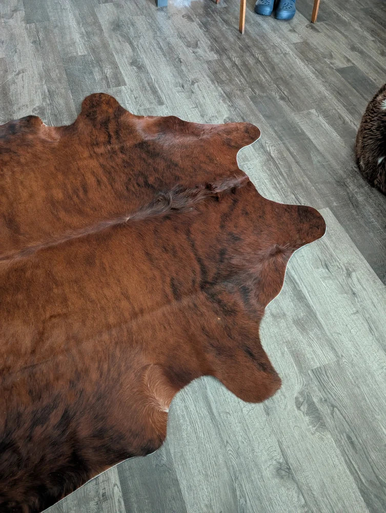 Brown large cowhide rug with natural fur texture and irregular edges perfect for beautiful rugs with unique characteristics