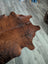 Brown large cowhide rug with natural fur texture and irregular edges perfect for beautiful rugs with unique characteristics