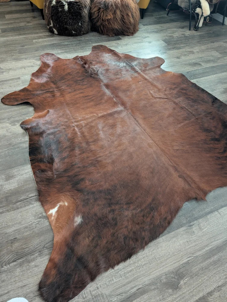 Brown large cowhide rug with natural fur texture and irregular edges showcasing unique characteristics for beautiful rugs