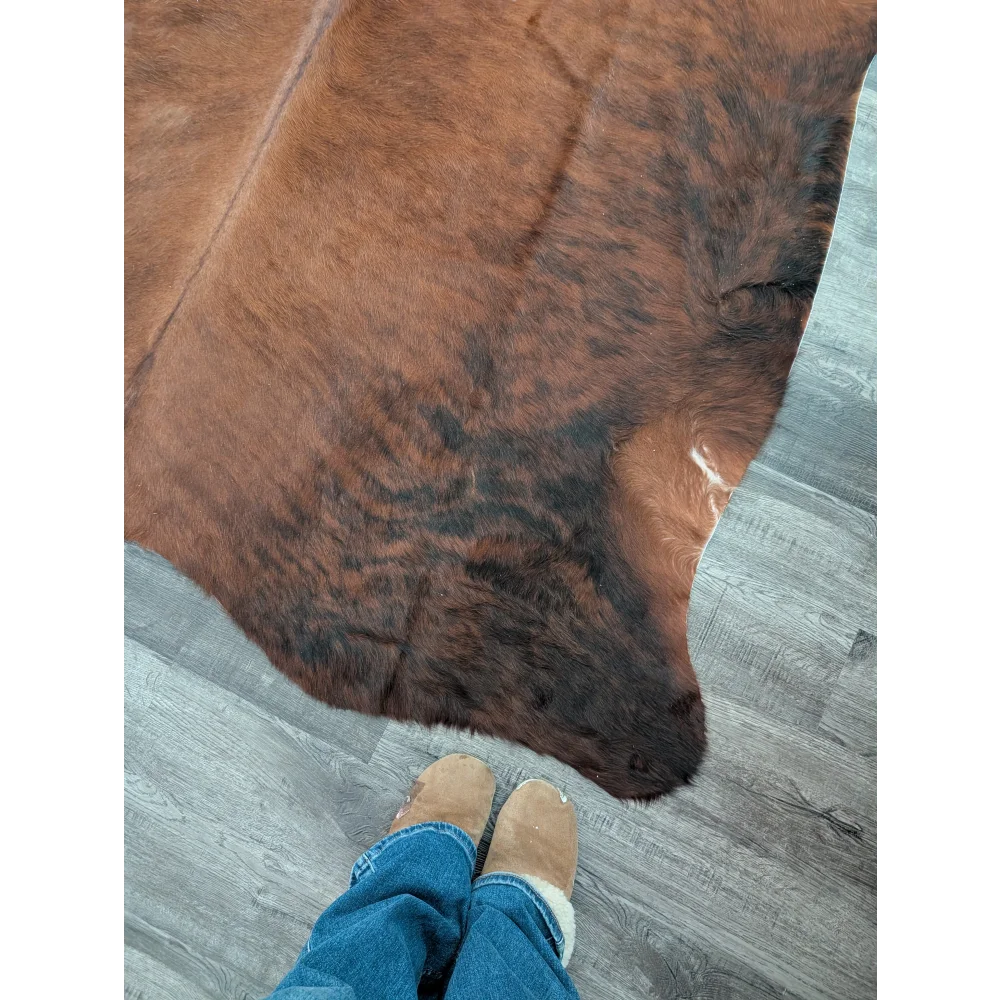 Brown and black large cowhide rug with natural fur texture showcasing unique characteristics for beautiful rugs