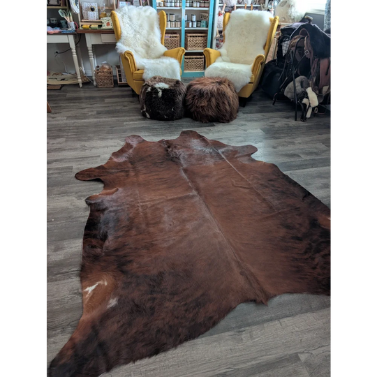 Brown large cowhide rug with natural fur texture and irregular edges showcasing unique characteristics and beautiful rugs