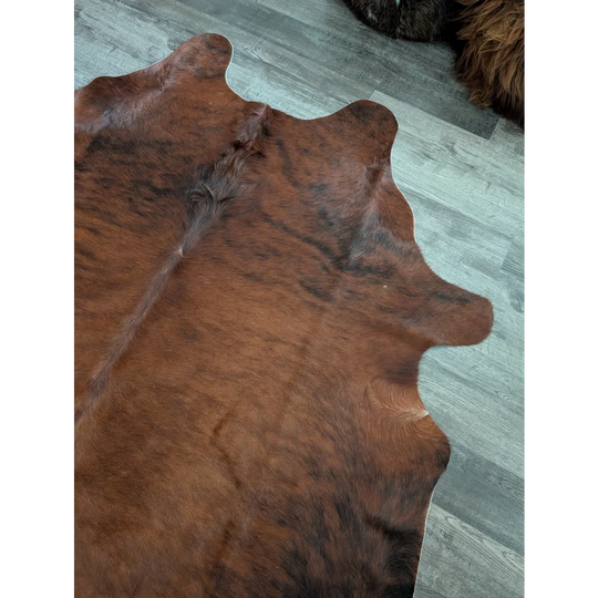 Brown and black large cowhide rug with natural fur texture showcasing unique characteristics and beautiful rugs design