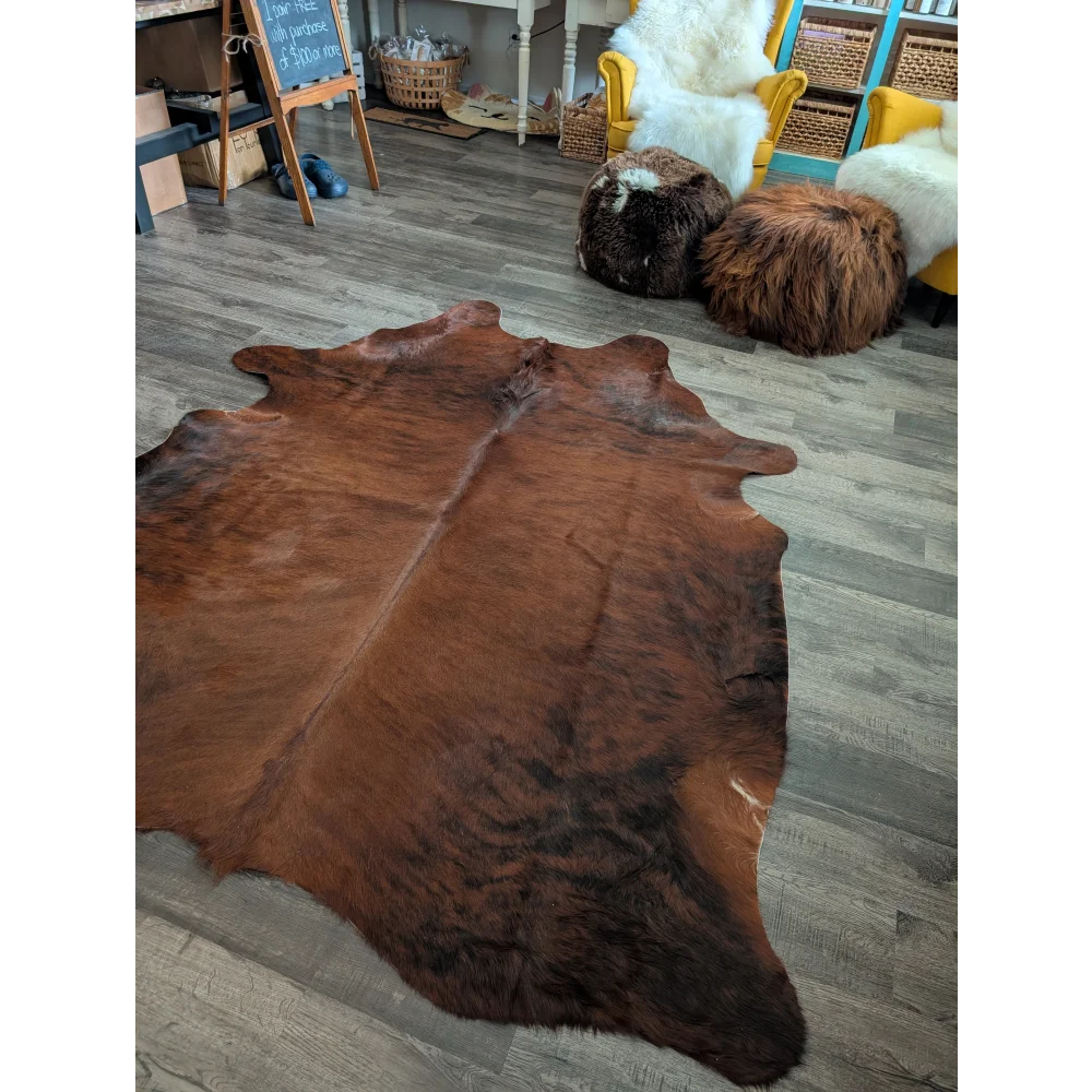 Rich brown large cowhide rug with natural fur texture and irregular edges showcasing unique characteristics