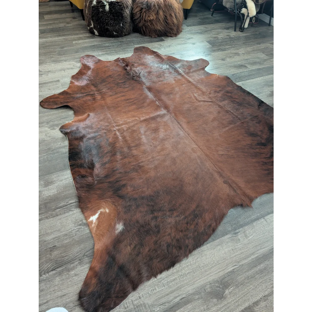 Brown large cowhide rug with natural fur texture and irregular edges showcasing unique characteristics for beautiful rugs