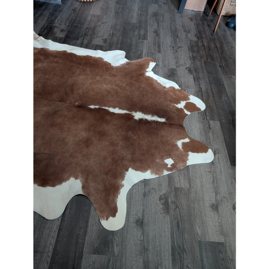 Brown and white large cowhide rug with natural fur texture showcasing unique characteristics and beautiful rugs style