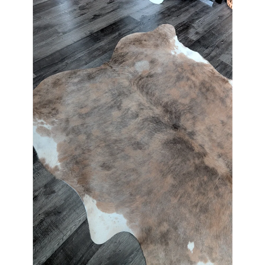 Brown and white large cowhide rug with natural fur texture showcasing unique characteristics for beautiful rugs