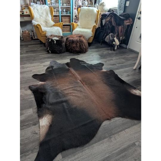 Large cowhide rug with brown and black natural fur texture showcasing unique characteristics in beautiful rugs