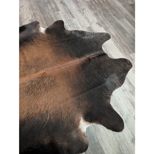 Beautiful large cowhide rug with brown and black natural fur texture showing unique characteristics