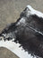 Large black and white cowhide rug with natural fur texture showcasing beautiful rugs and unique characteristics