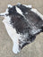 Large cowhide rug with black and white natural irregular edges showcasing unique characteristics and beautiful rugs style