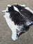 Large black and white cowhide rug with natural fur texture featuring unique characteristics for beautiful rugs