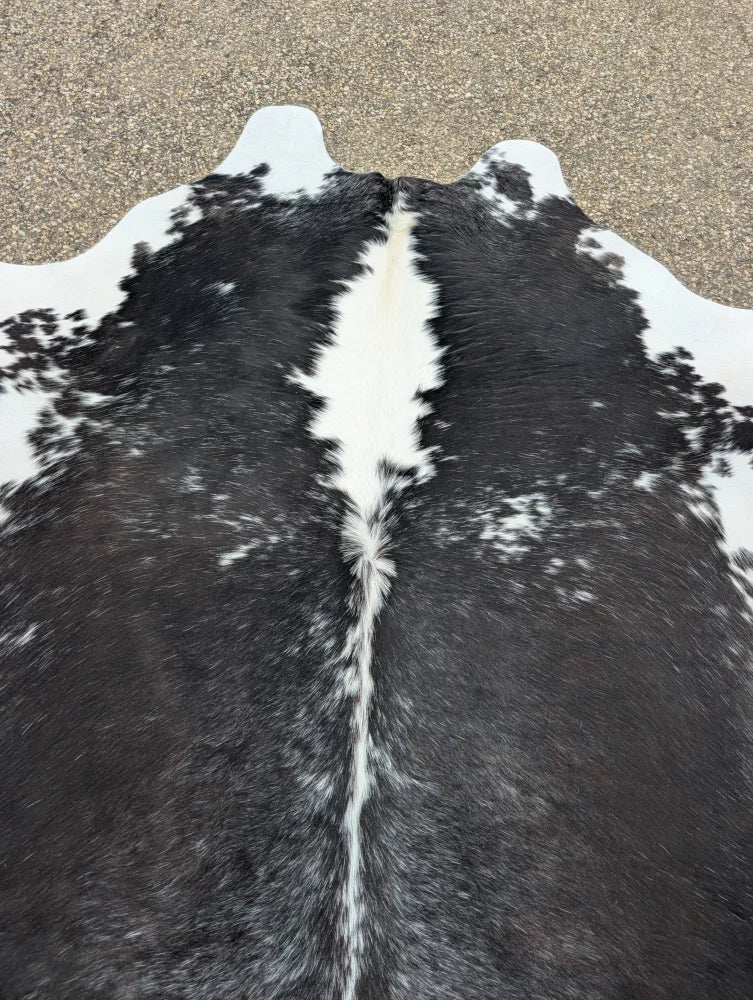 Large black and white cowhide rug with natural texture showcasing unique characteristics and perfect for beautiful rugs collection