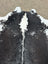Large black and white cowhide rug with natural texture showcasing unique characteristics and perfect for beautiful rugs collection