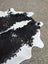 Large cowhide rug with black and white natural irregular edges showcasing unique characteristics for beautiful rugs