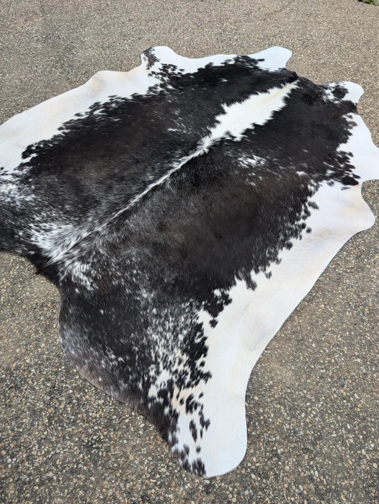 Black and white large cowhide rug with natural fur texture showcasing unique characteristics and beauty
