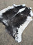 Black and white large cowhide rug with natural fur texture showcasing unique characteristics and beauty