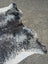 Extra large black and white speckled cowhide rug with natural edges showcasing unique characteristics for beautiful rugs