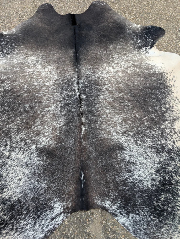 Extra large black and white speckled cowhide rug with natural texture showcasing unique characteristics and beautiful rugs design