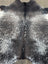 Extra large black and white speckled large cowhide rug with natural textured surface featuring unique characteristics