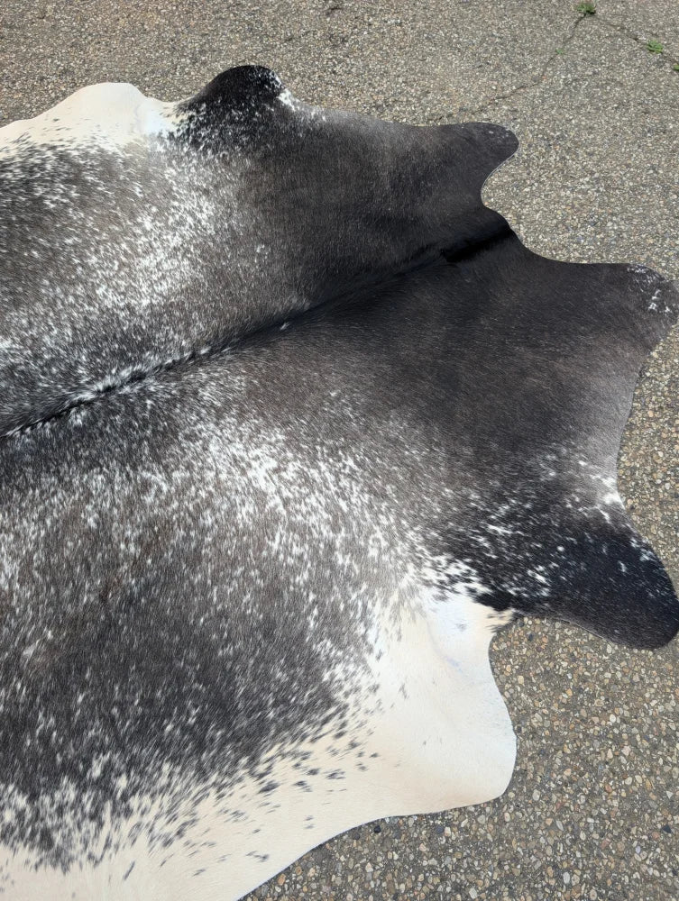 Extra large black and white cowhide rug with natural irregular edge showcasing unique characteristics and beautiful rugs style
