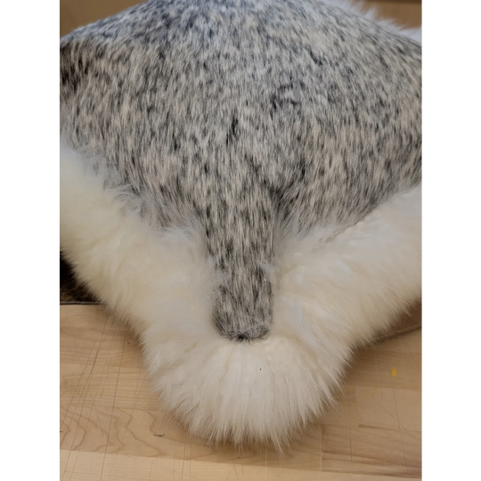 A plush gray and white speckled faux fur merino sheepskin cushion with fluffy white border by angus oliver canada